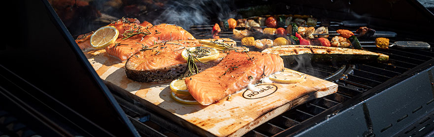 Lachs wird auf Räucherplanke auf dem Grill gegrillt